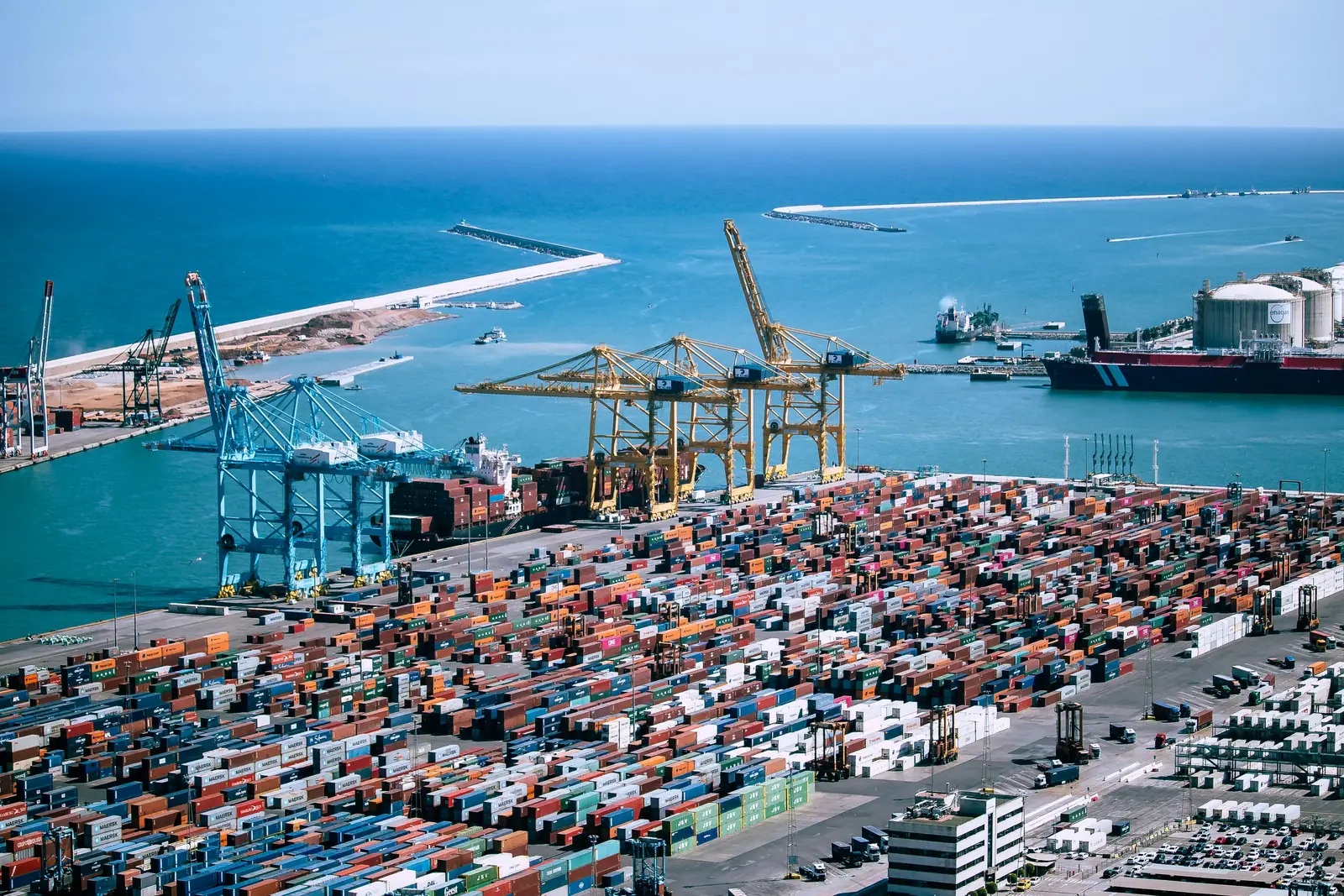 Aerial view of a container terminal with thousands of stacked containers beside the sea